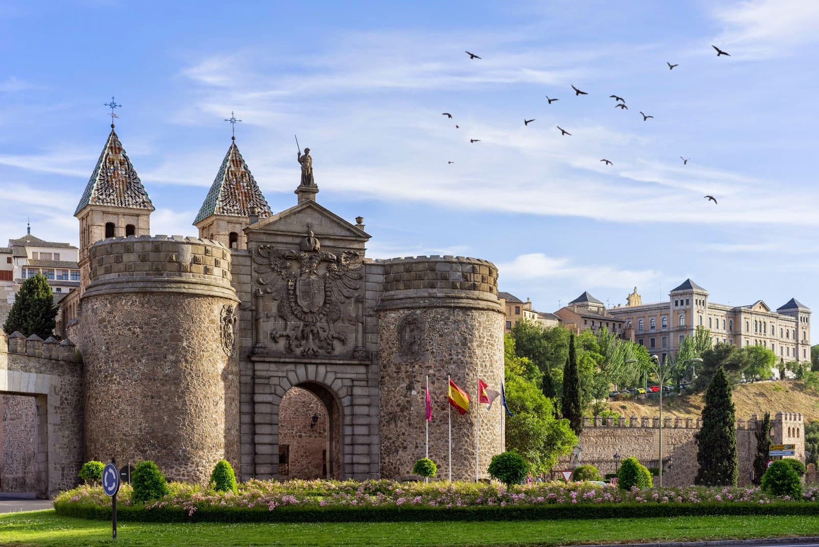 Medieval stone gate and towers at Toledo city entrance, daytime