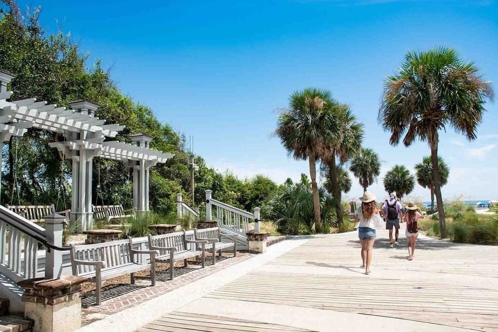 People walking and biking along palm-lined Hilton Head boardwalk