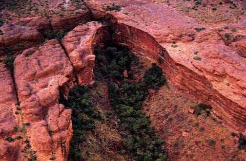Aerial helicopter view of red rock canyon and natural arch