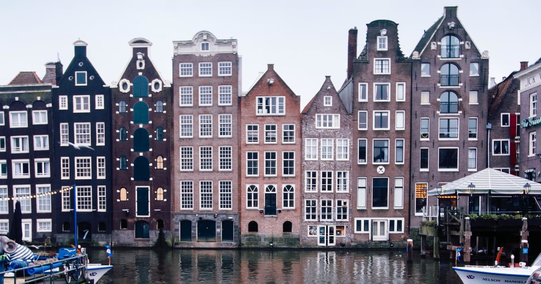 Historic Amsterdam canal houses lining waterway at day