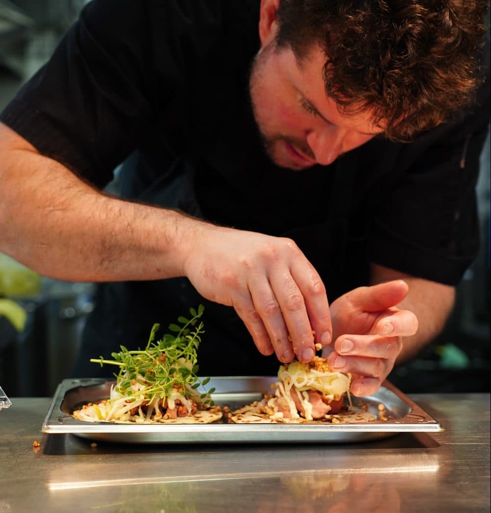 Chef plating traditional Czech street food in professional kitchen
