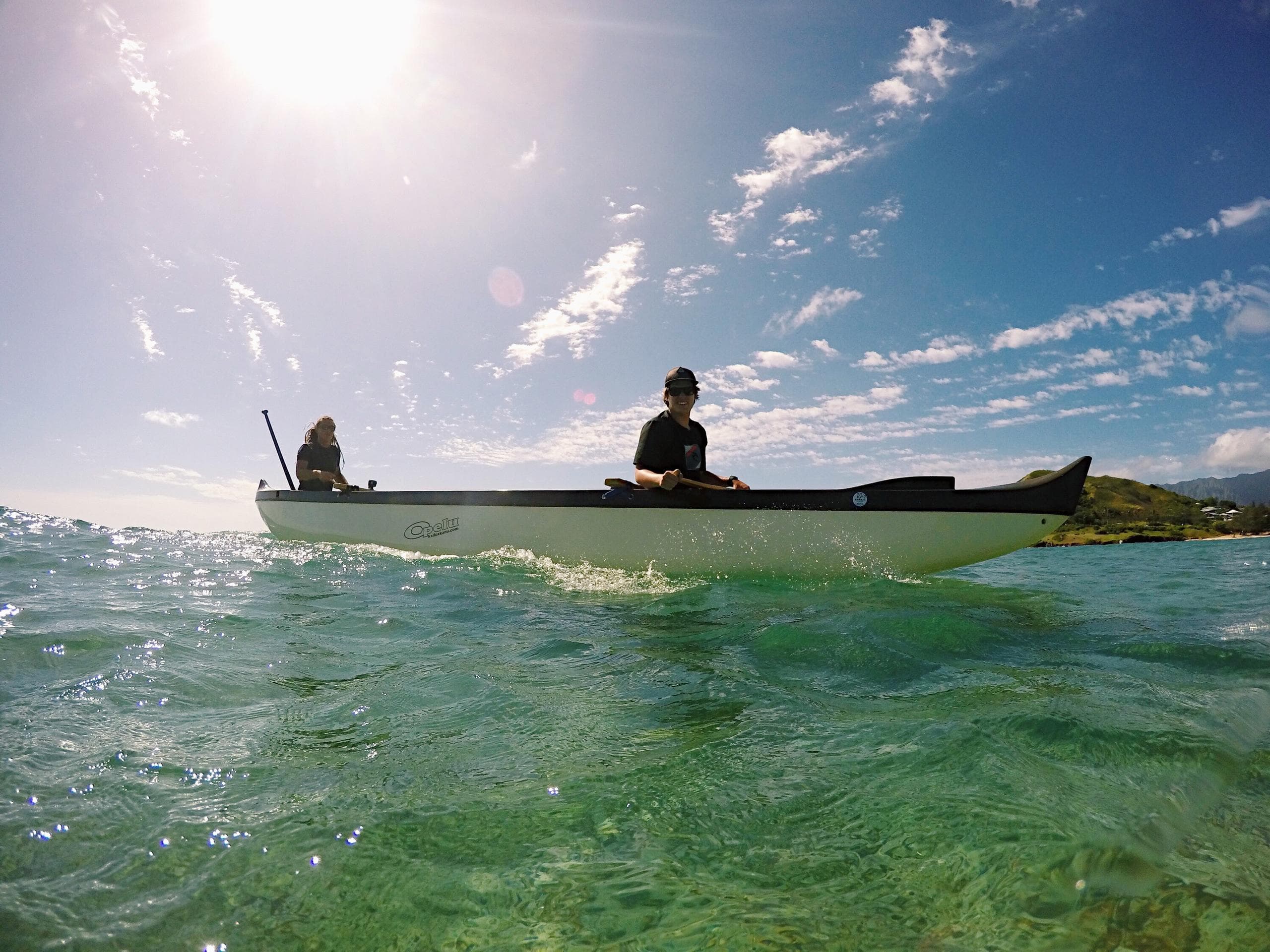 Kayakers paddling shallow turquoise waters under bright sun