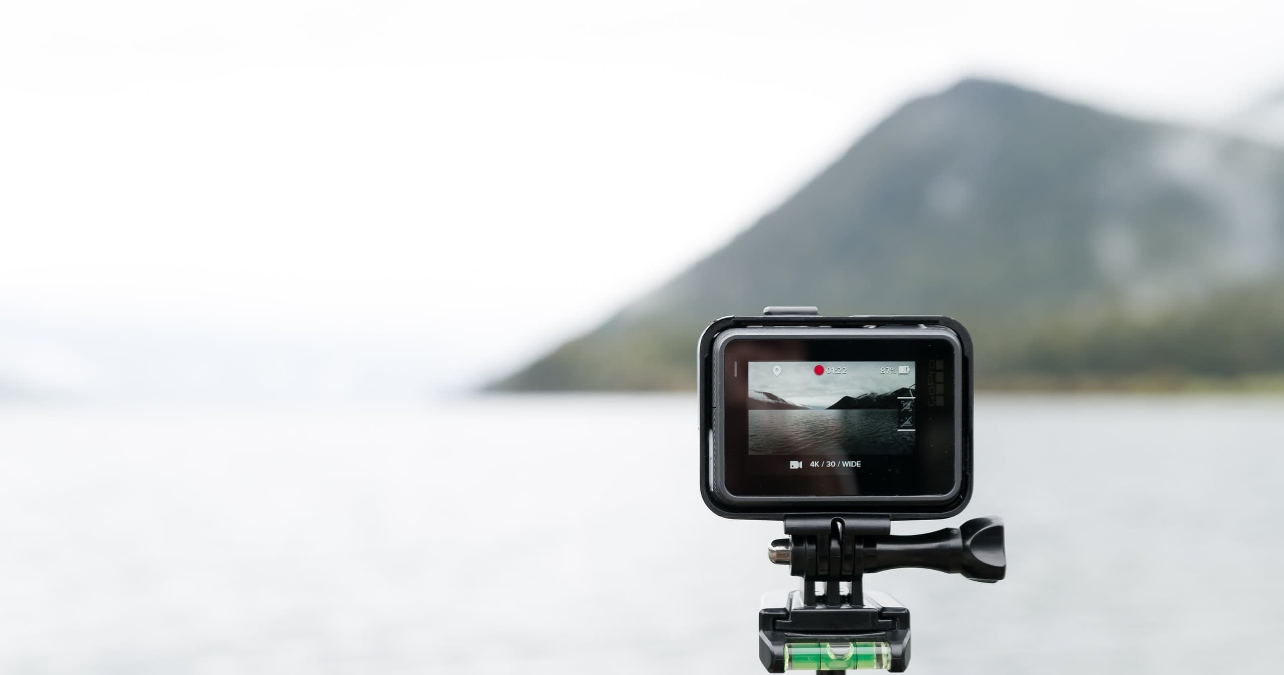 Action camera mounted capturing coastal mountain and sea vista