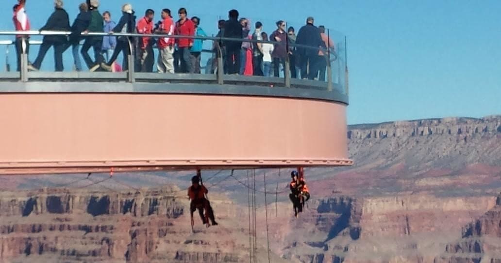 Tourists on Grand Canyon skywalk with rappelling guides below