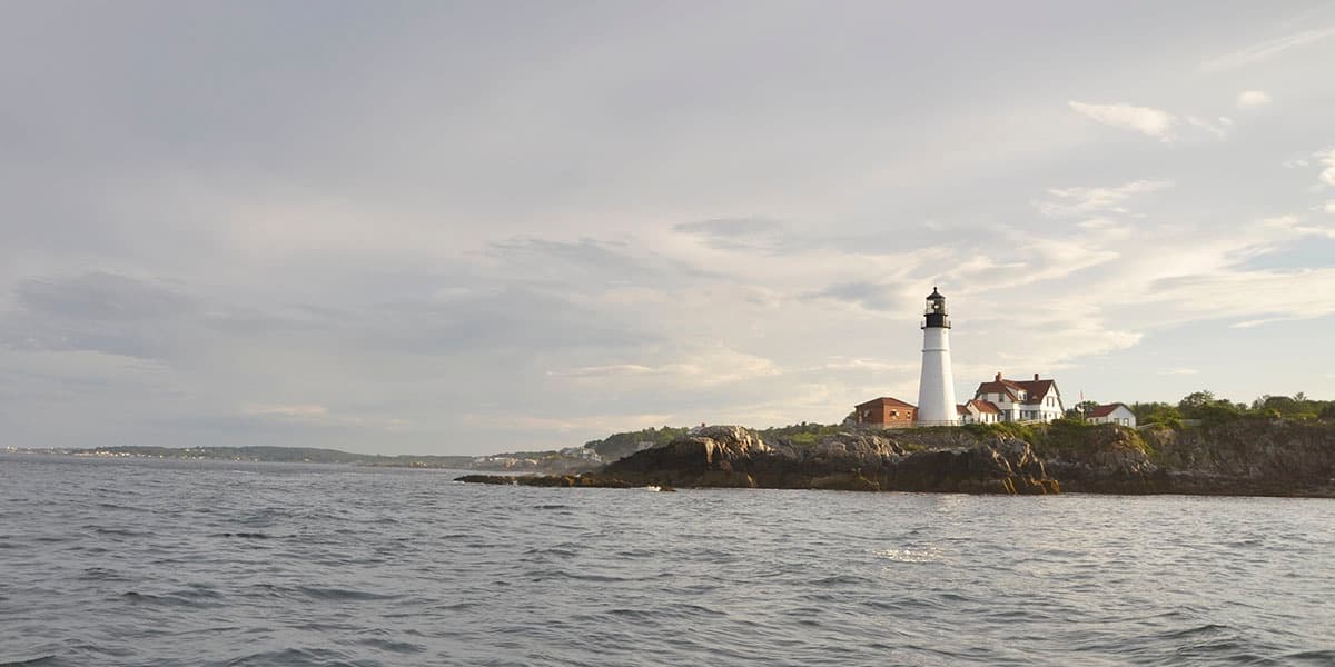 Lighthouse and coastal horizon in Casco Bay during calm day