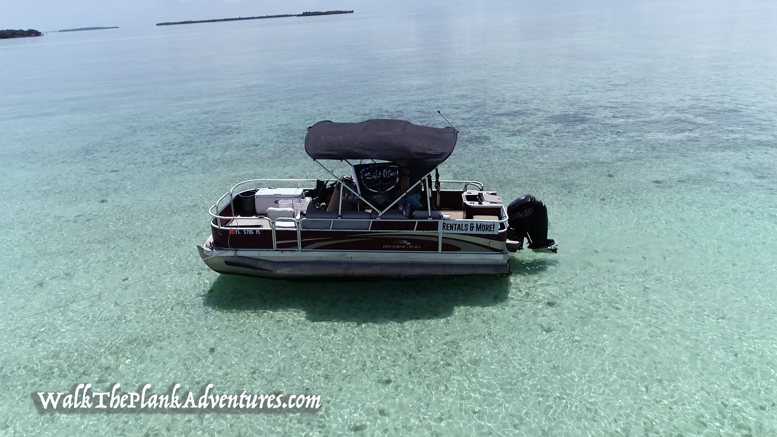 Pontoon boat anchored on crystal shallow sandbar, private island boat tour