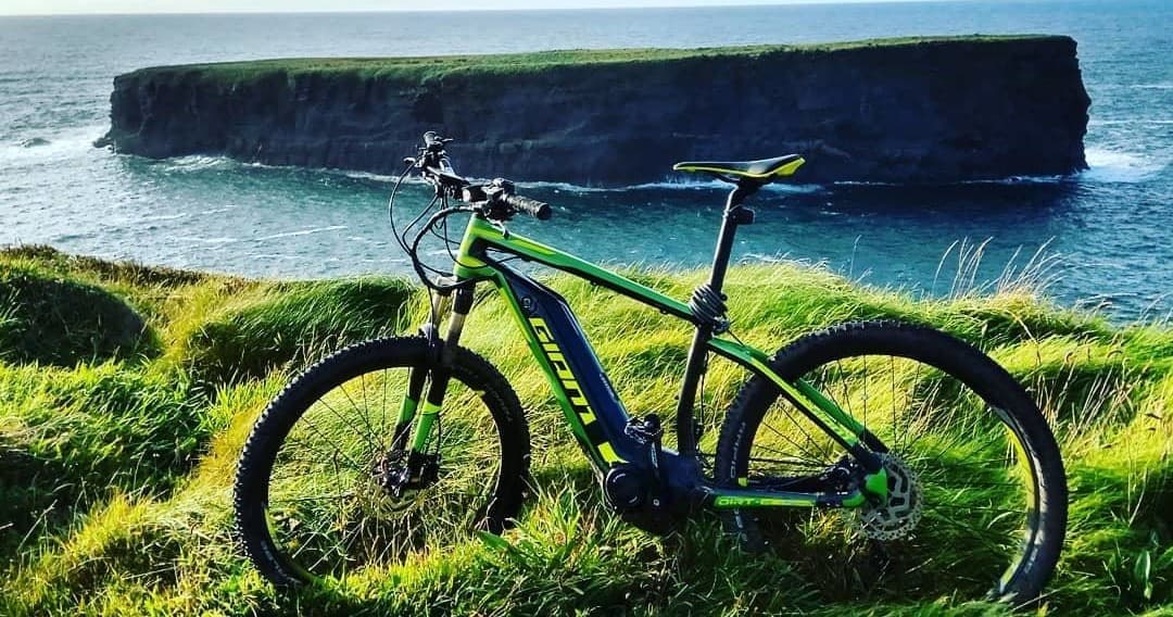 E-bike on grassy Loop Head cliff overlooking Atlantic Ocean