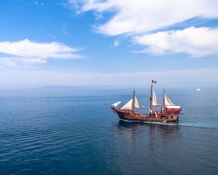 Traditional sailing ship cruising calm open sea under blue sky