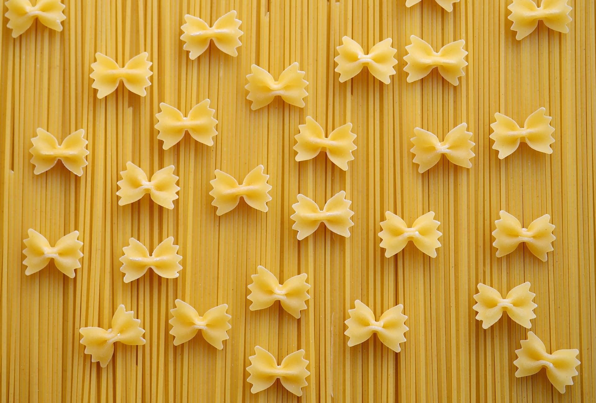 Bowtie and spaghetti pasta arranged in kitchen flatlay