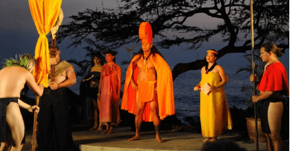 Traditional Hawaiian luau performers by seaside at dusk
