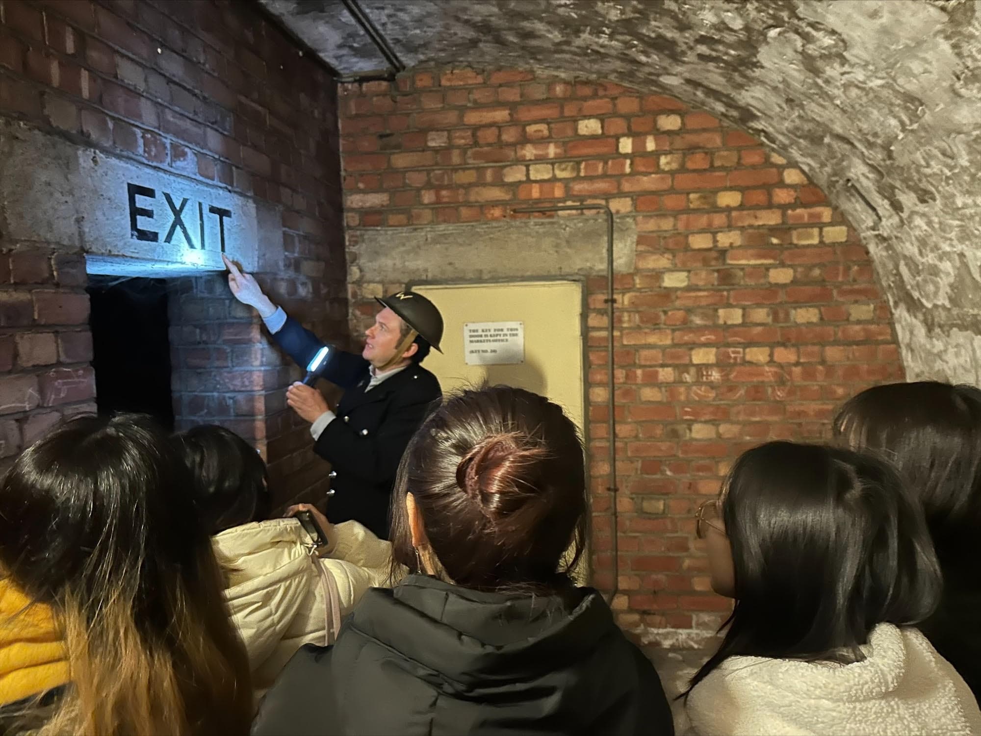 Guide leading underground historical tour in brick cellar