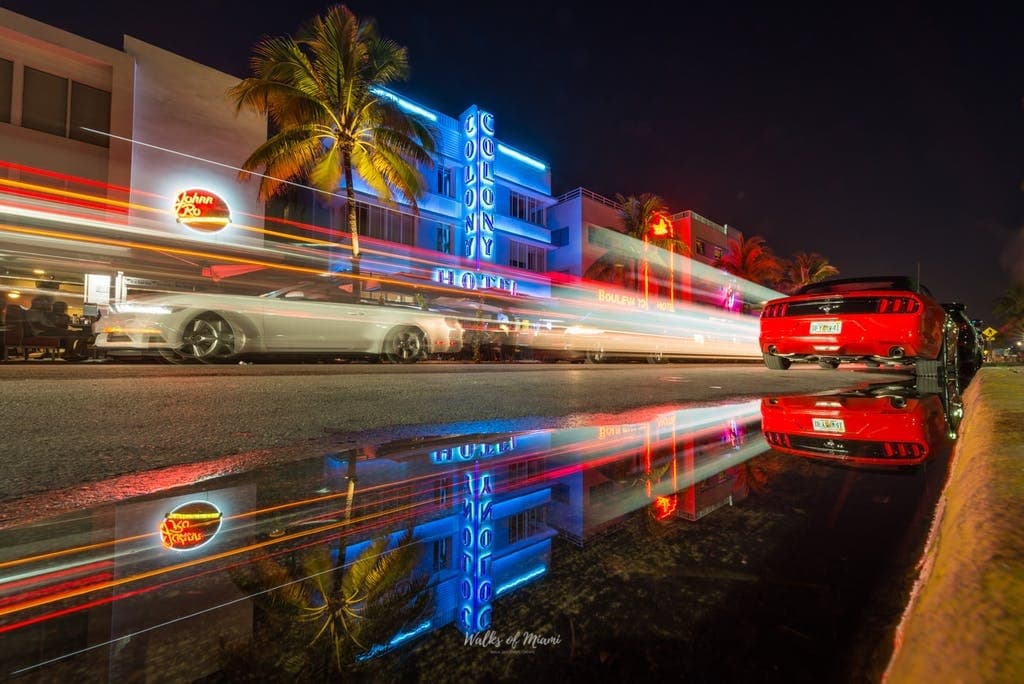 Neon-lit Ocean Drive cars with reflections, Miami nightlife
