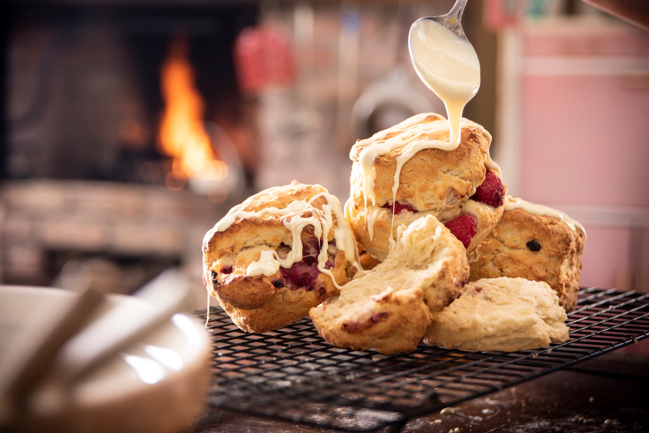 Warm scones with cream drizzling in cozy bakery kitchen scene