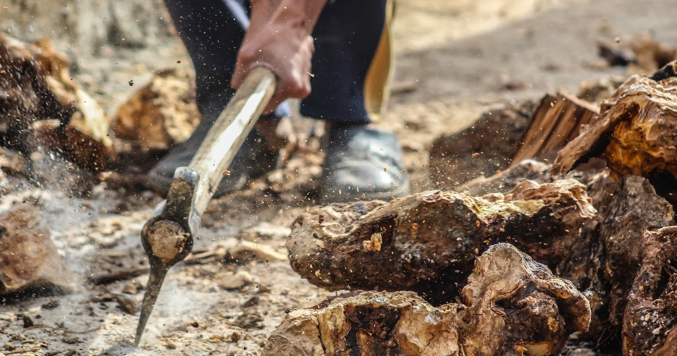 Using pickaxe to break rock in outdoor terrain