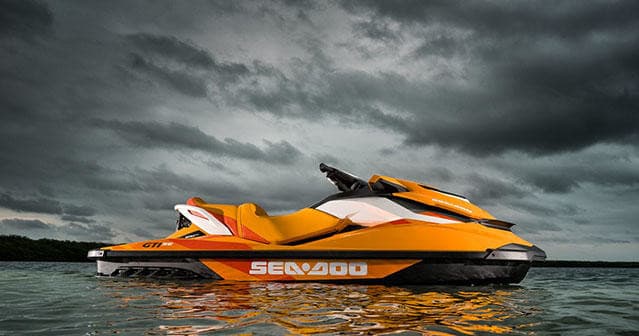 Orange Sea-Doo jet ski on open water with dramatic cloudy sky