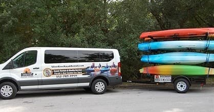 Kayak rental van and stacked kayaks at put-in area