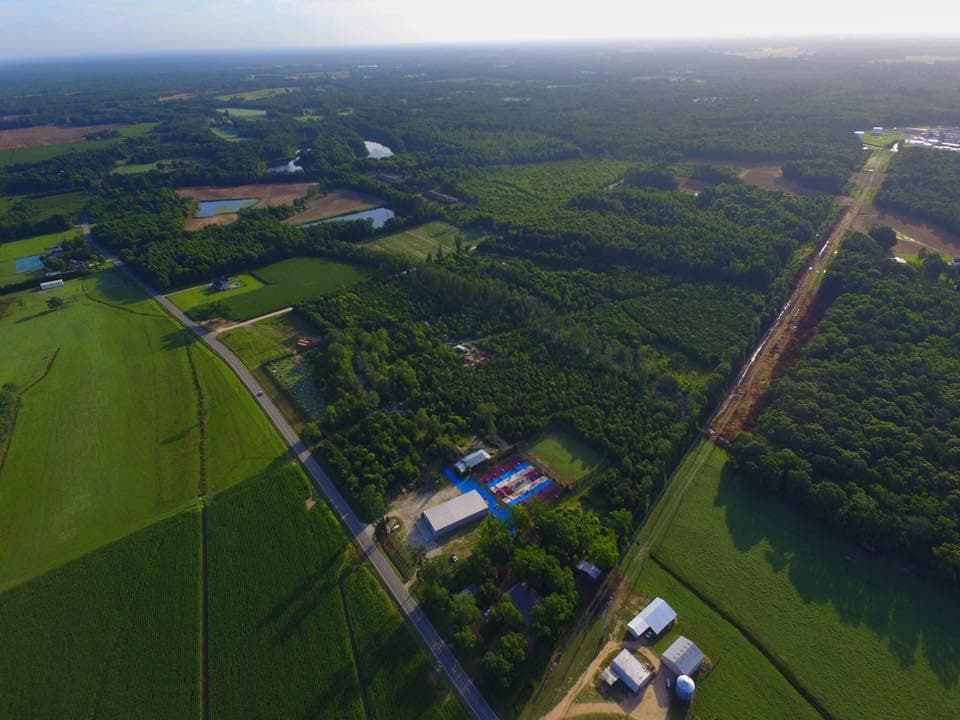 Aerial view of expansive outdoor paintball fields and forest