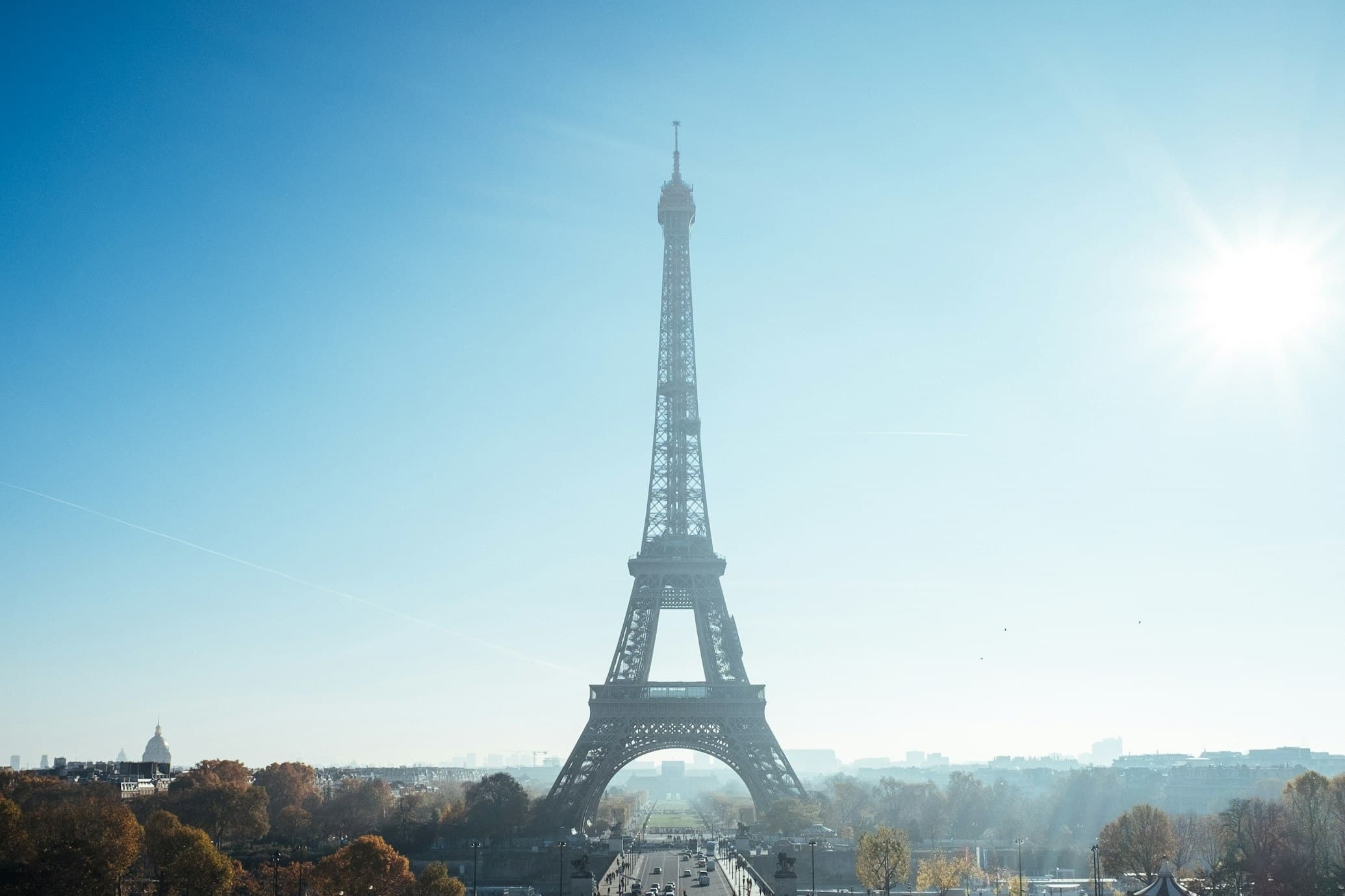 Eiffel Tower with bright sun haze, panoramic Paris skyline