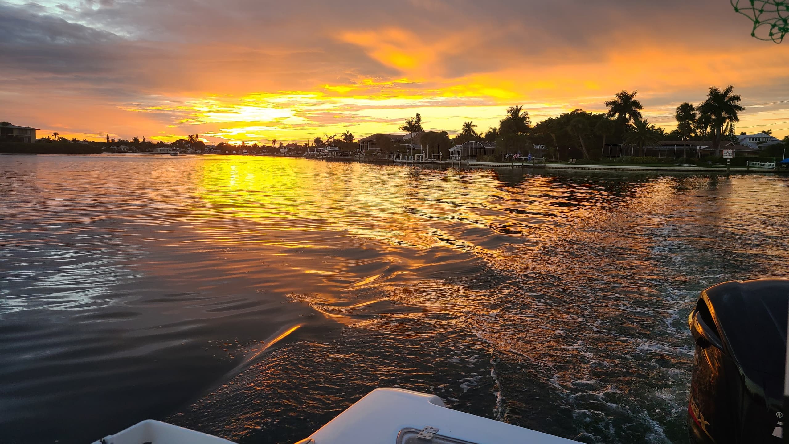 Boat cruising at sunset with rippled water in coastal bay