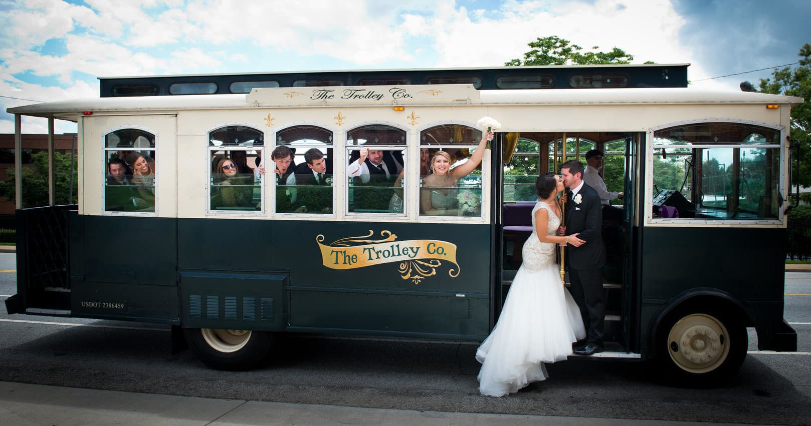 Wedding couple boarding vintage trolley on city street