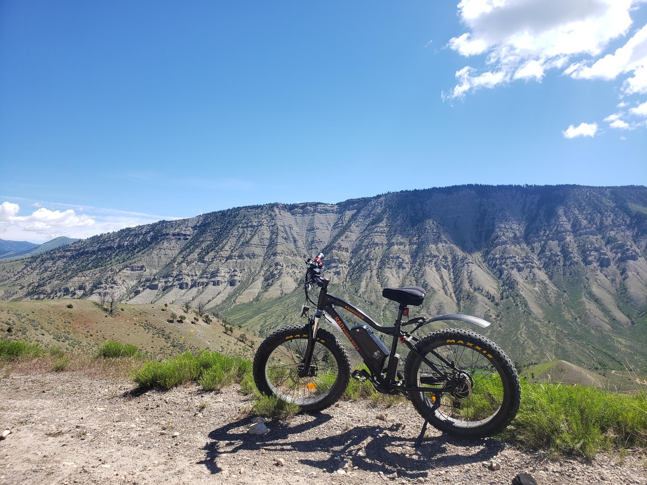 E-bike perched on rocky overlook with layered mountain views