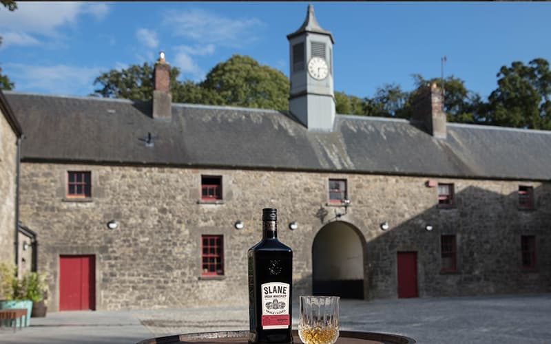Distillery courtyard with bottle and glass on barrel outdoors