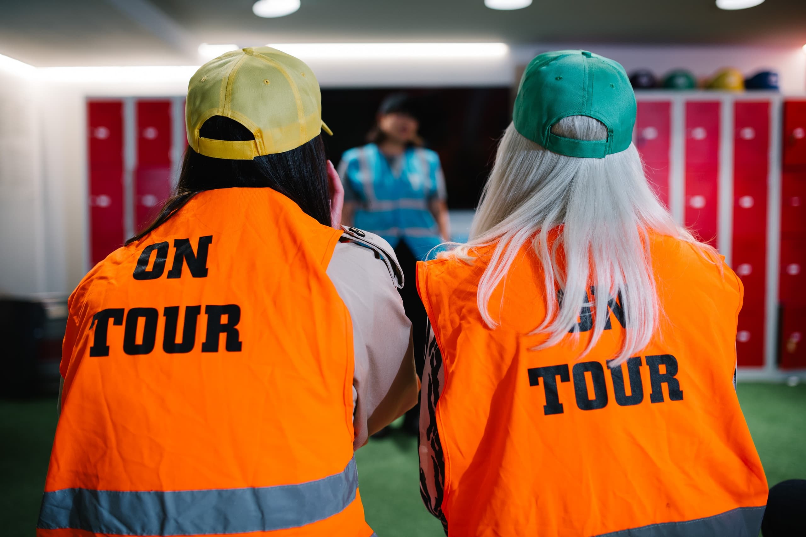 Two tour participants in high-vis jackets viewing brewery displays