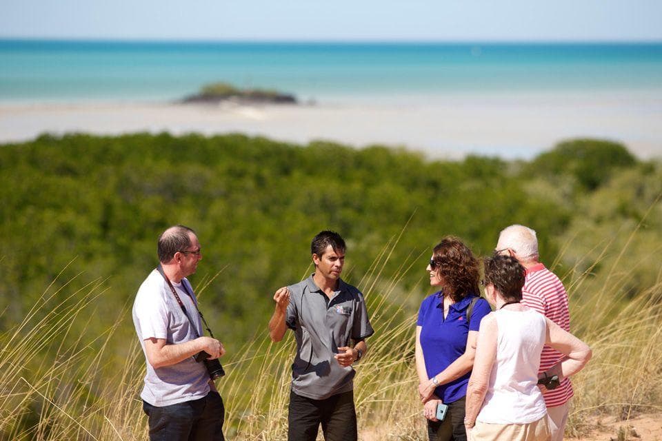 Small guided group chatting on sandy coastal dunes near Broome