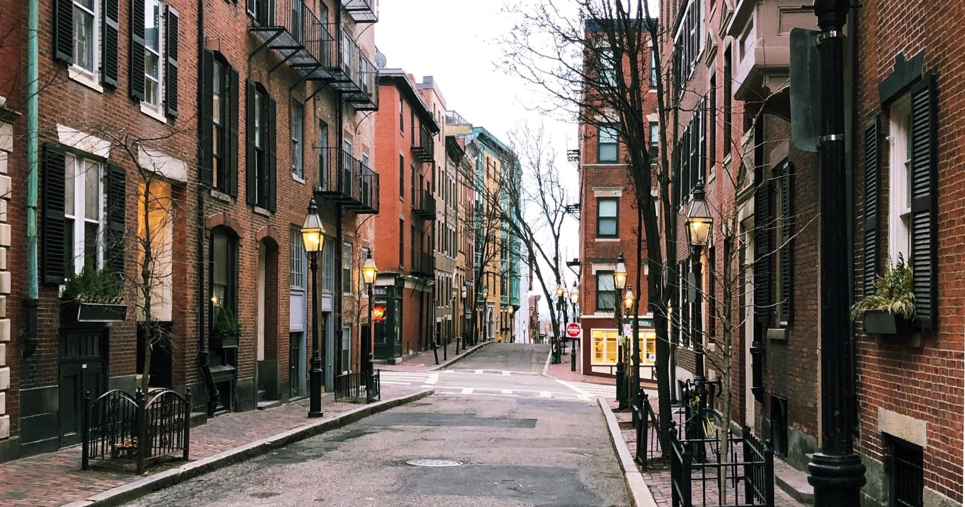 Historic brick row houses along quiet cobblestone city lane