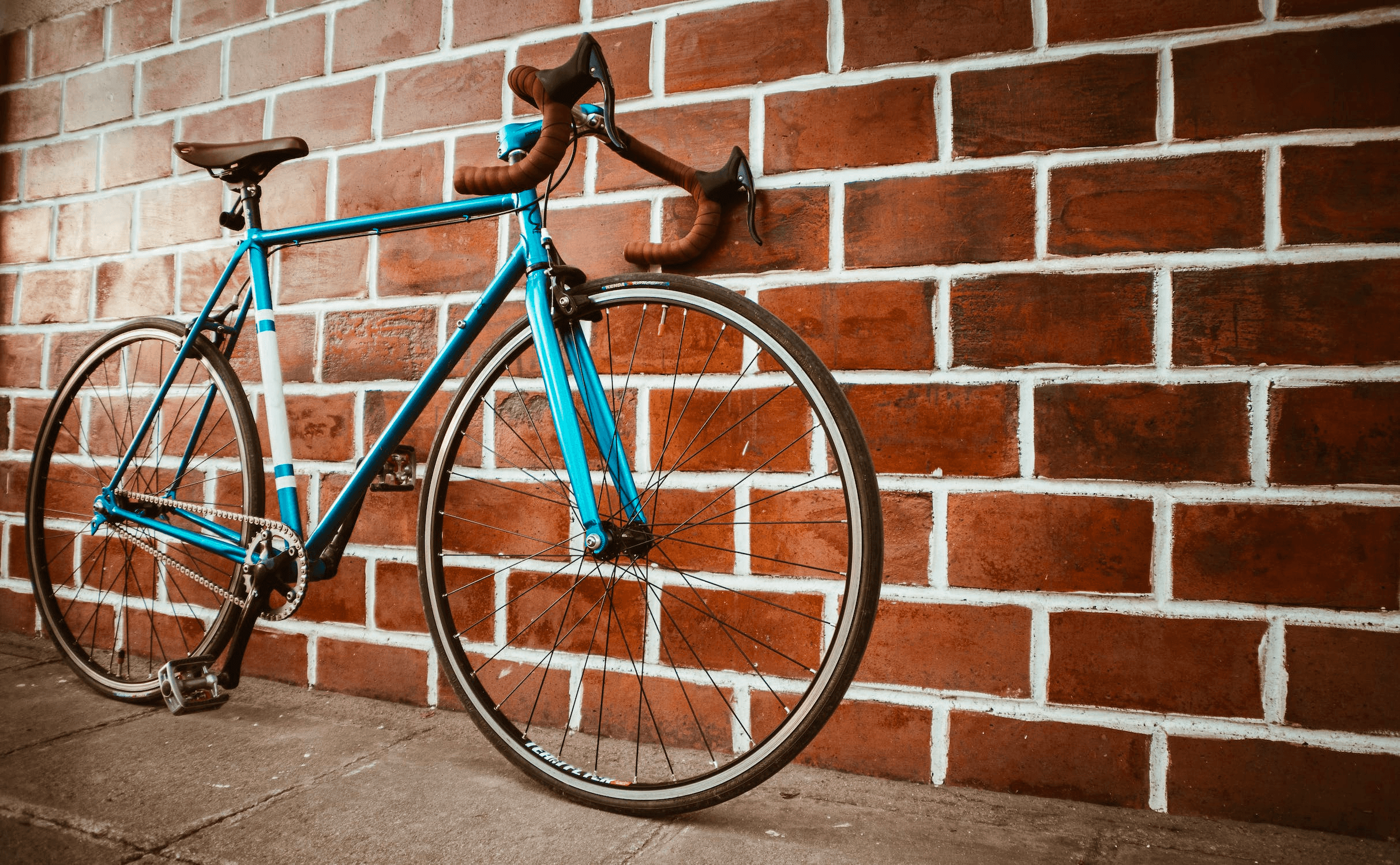 Vintage road bike leaning against brick wall, urban cycling photo