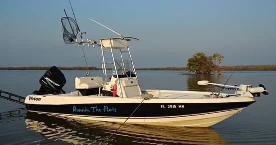 Skiff boat on shallow flats at golden hour ready for fishing
