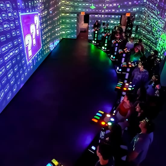 Players at electronic quiz stations in immersive indoor arcade room
