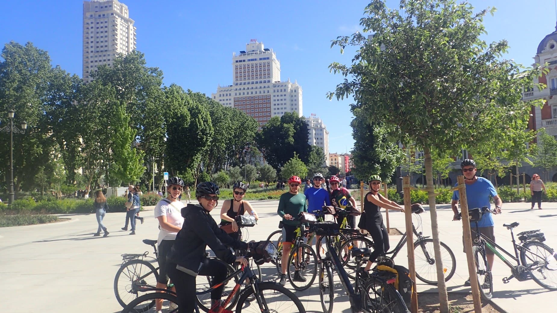 Urban bike tour with riders in city park and skyline backdrop
