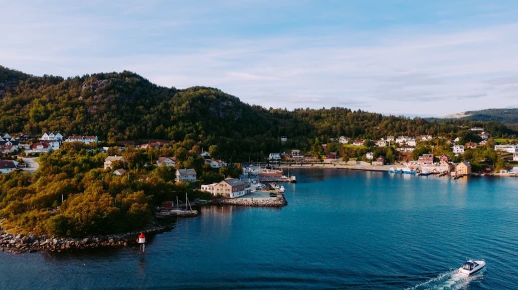Aerial coastal town and fjord shoreline with boats at harbor