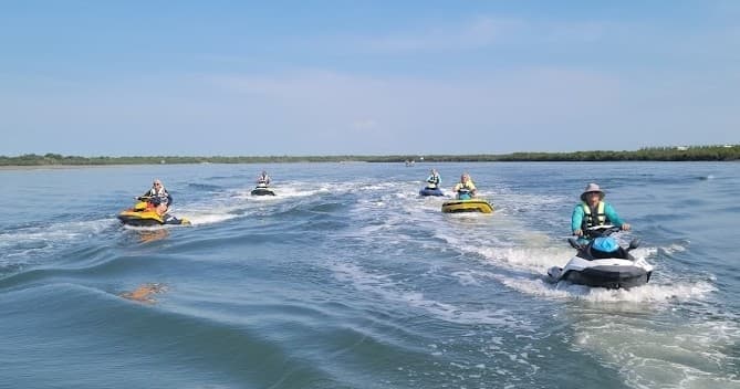 Multiple jet skis carving wakes on coastal bay waters