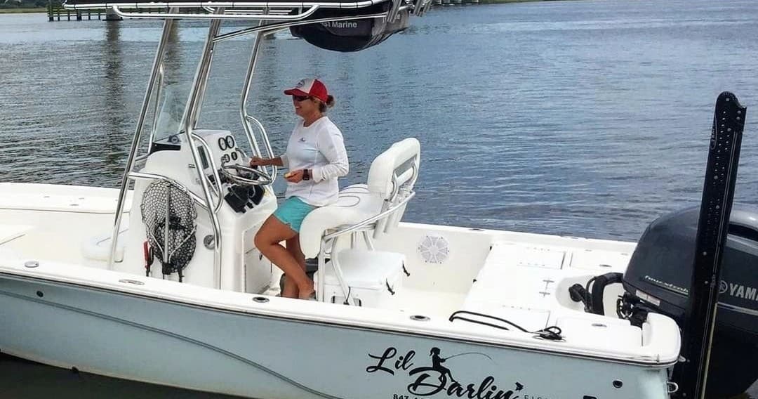 Captain steering center-console charter boat on coastal inlet