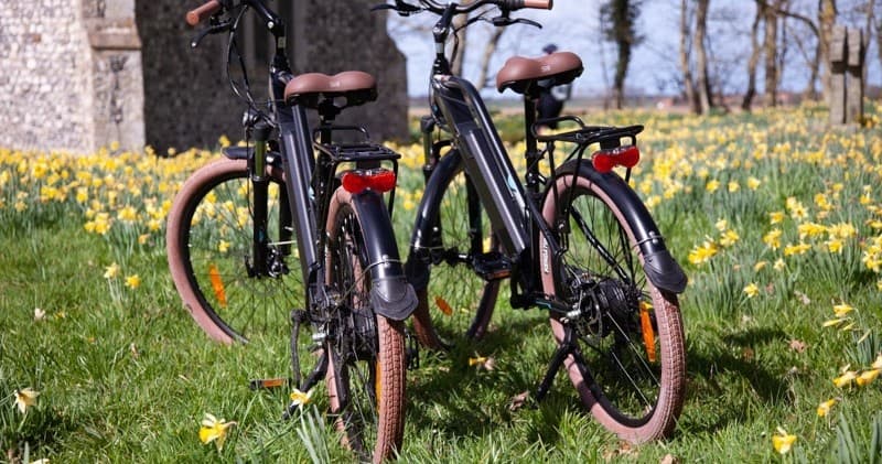 Bike tour bicycles parked in daffodil meadow near church