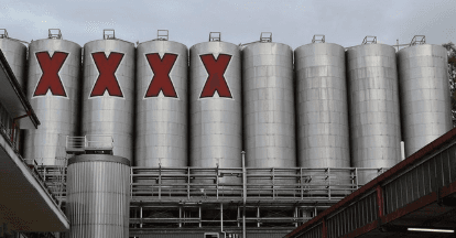 Large brewery fermentation tanks with red X logos at plant