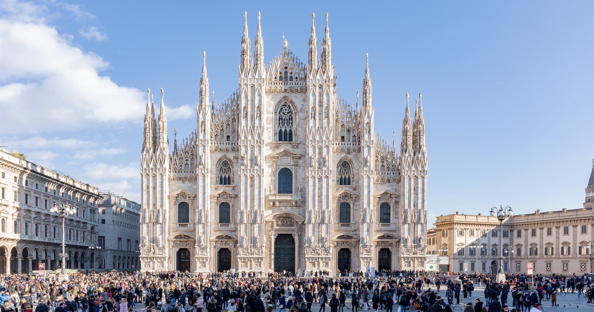 Crowded Milan Duomo square with cathedral facade, city walking tour
