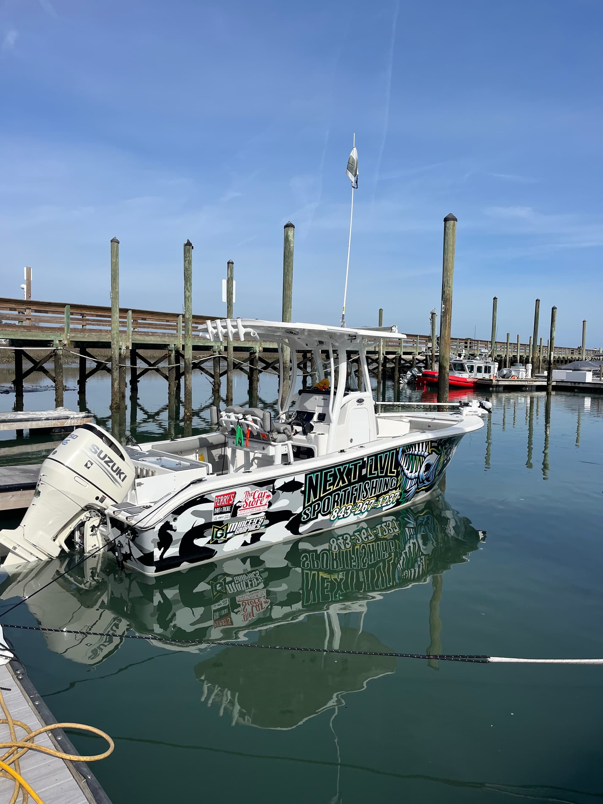 Docked sportfishing boat reflected in marina, pre-trip staging