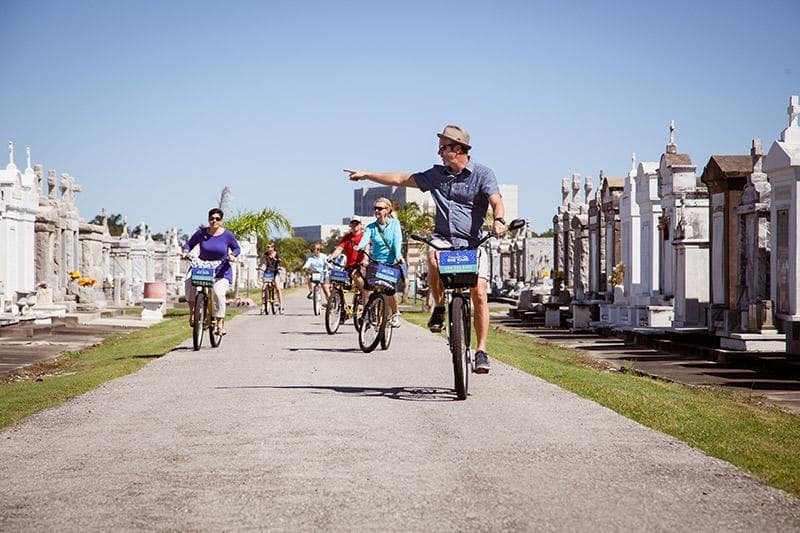 Cyclists riding through historic above-ground cemetery on guided bike tour