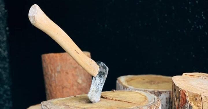 Hatchet embedded in wooden stump at indoor axe throwing lane