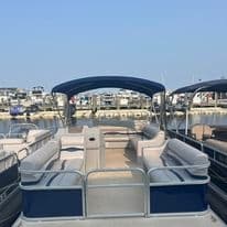 Pontoon boat seating at marina, leisure cruising on calm harbor