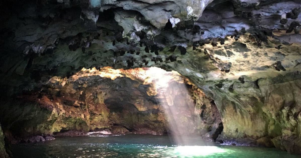 Sunlit sea cave with crystal water and dramatic light beam