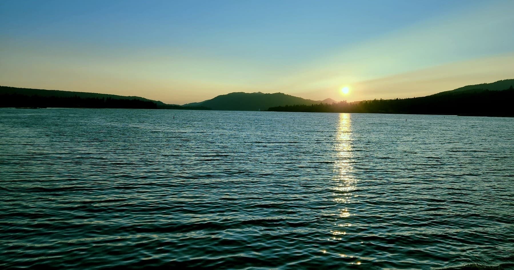 Sunset over Big Bear Lake with open water and horizon