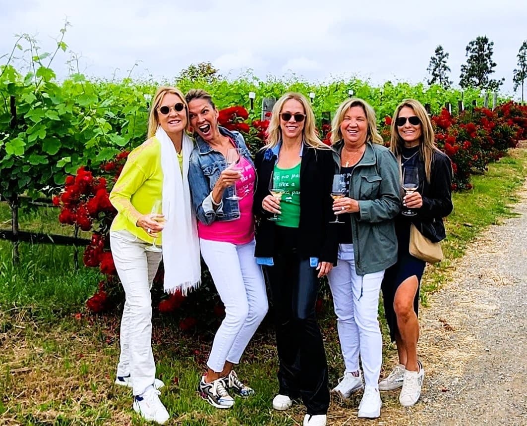 Group of friends posing for photo during vineyard tour