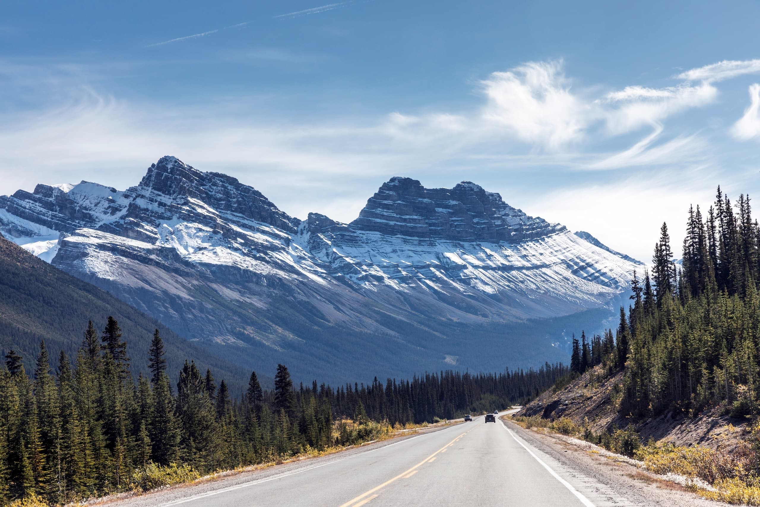 Scenic highway leading into snow-capped Rocky Mountains, Alberta