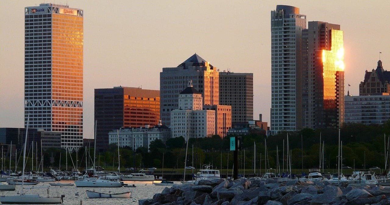 Milwaukee skyline at sunset with sailboats on Lake Michigan harbor