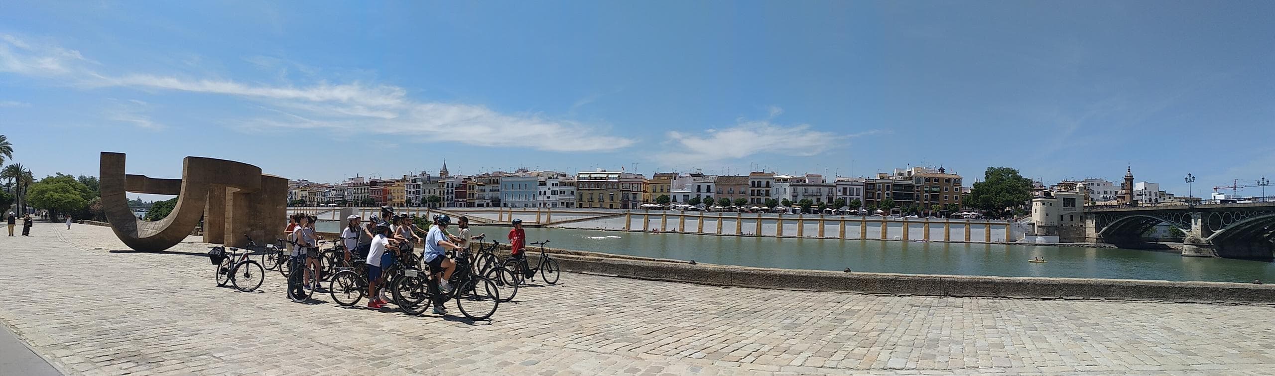 Panoramic riverside promenade with bikes and skyline view