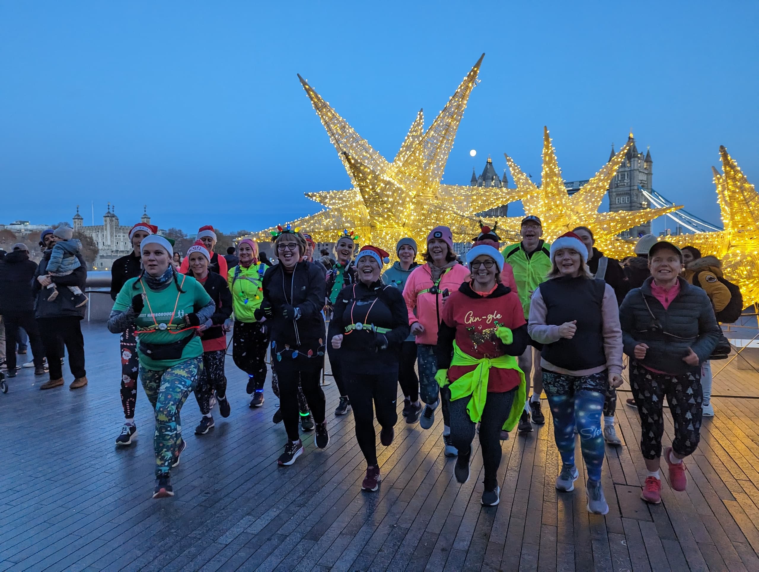 Night fun run group under illuminated star installation on pier